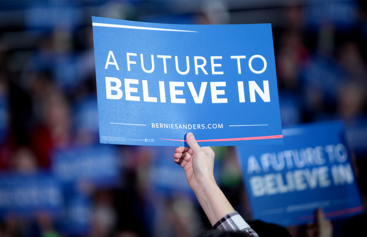 A patron holds a "Future to Believe in" poster in support of Bernie Sanders and his message of legalizing marijuana.