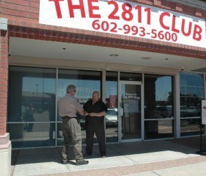 An officer stands in front of the 2811 cannabis club building in Arizona as it is being raided.
