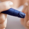 A diabetic pricks fingertip with blood glucose meter, which can be evened out with marijuana.