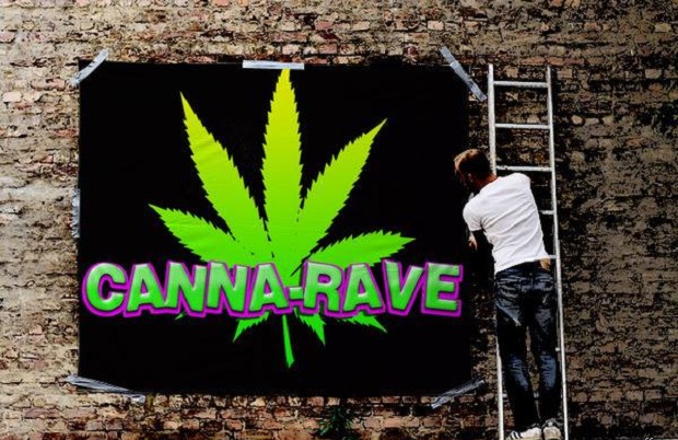 A man pastes up poster for Denver's first Canna-Rave.