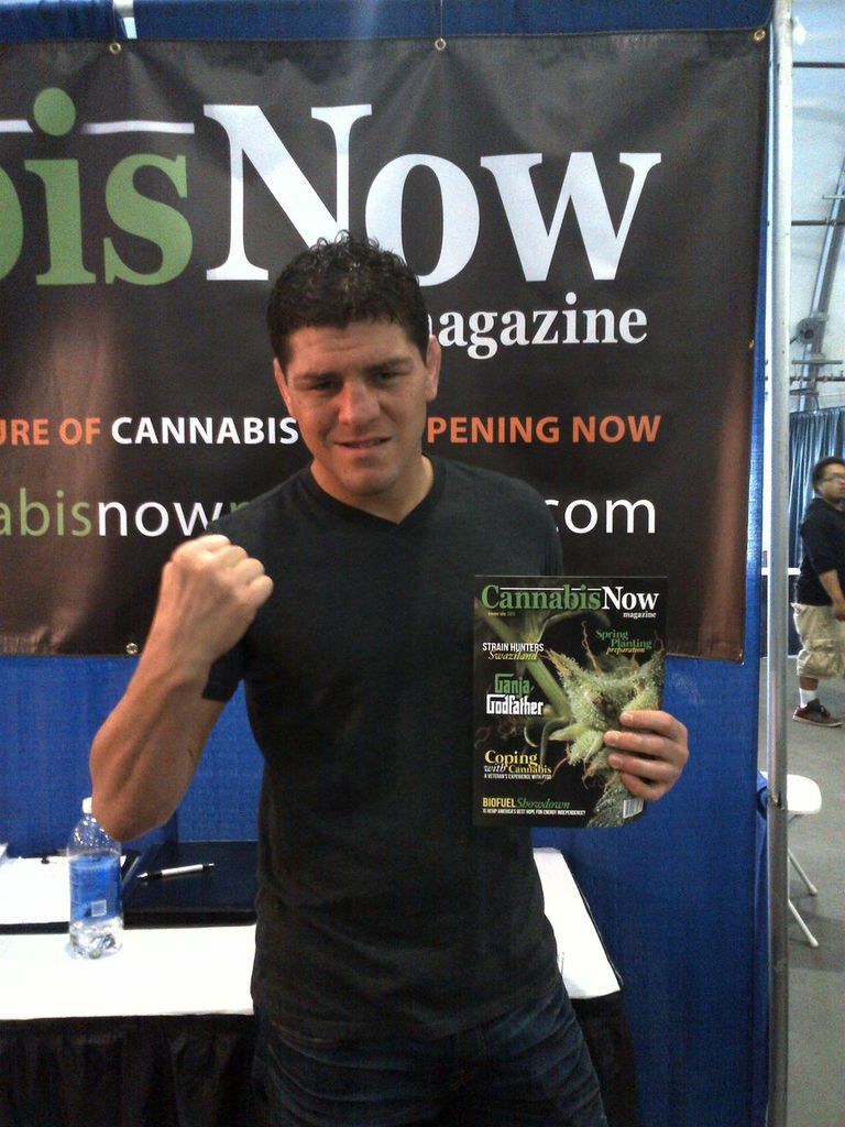 Nick Diaz flexes as he poses for a picture with issue 2 of Cannabis Now.