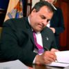 Chris Christie purses his lips as he signs a bill that allows children in his state access to MMJ.