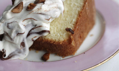 A purple rimmed cake holds an infused hazelnut bundt cake with nutella topping.