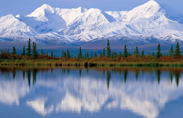 Beautiful picture of mountains in Alaska, the next state to possibly legalize, reflected in a large lake in early spring.