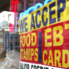 A red and yellow sign informs customers of what payments can be used, including food stamps at a grocery store. Unfortunately, food stamps do not cover MMJ in CO.