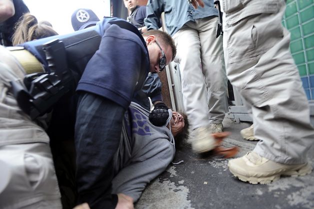 Jose Gutierrez, a journalist and marijuana activist, on the ground as he is brutally arrested during the April 2012 federal raids on Oaksterdam University.
