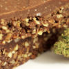 Crunchy brownies with a fudge topping sit next to a bud of marijuana.