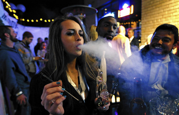 A young girl exhales a dab hit in a club, where onsite consumption is acceptable.