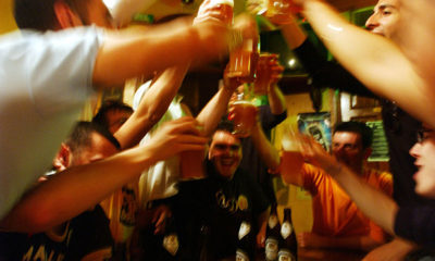 A group of people at a party all cheersing one another while binge drinking.