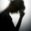 A silhouette of a woman holding her hand to her forehead to represent her anxiety, which can be treated with cannabis.