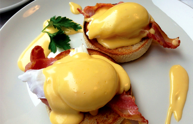 Two poached eggs sit atop toasted English muffins and topped with a Lemon Haze hollandaise sauce.