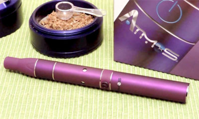 A purple wide view of the Atmos Raw next to a purple grinder full of cannabis.