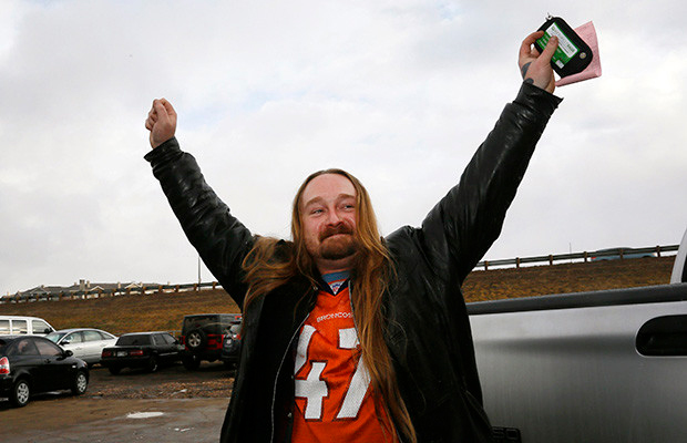 Jesse Phillips celebrates being the first person to legally buy recreational marijuana (in his left hand) at the BotanaCare store in Northglenn, Colorado, on Jan. 1, 2014.