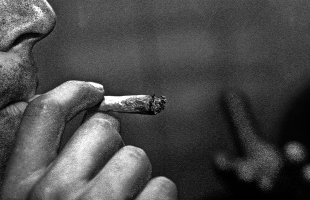 A man with a mental illness takes a hit from a joint filled with cannabis to ease his mind.