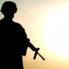 A silhouette of a soldier patrolling.