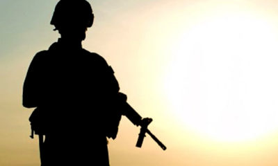A silhouette of a soldier patrolling.