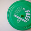 A green disc labeled "Puff-N-Pass" sits waiting to have a hit then thrown as a frisbee to the next person in the circle.