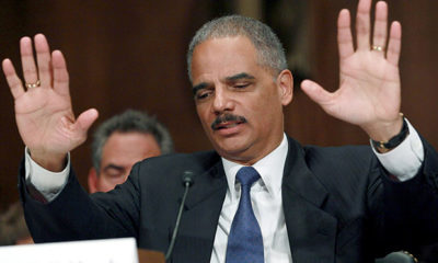 Attorney General Eric Holder holds his hands up in a session in which he failed to reschedule marijuana