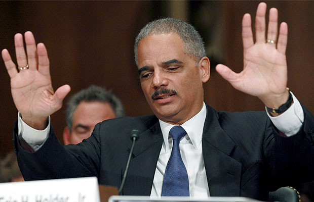 Attorney General Eric Holder holds his hands up in a session in which he failed to reschedule marijuana