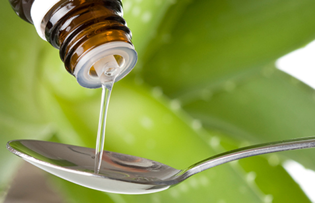 CBD oil pours out into a spoon as more and more states sign CBD only laws.