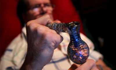 Tim Timmons holds a glass pipe filled with marijuana at his Garland home. Timmons smokes marijuana at night to ease pain caused by multiple sclerosis.