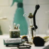 A Purr Mini-Bong sits on a bathroom counter along with a lighter and makeup items.