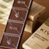 A Kiva edible chocolate bar sits outside of its box.