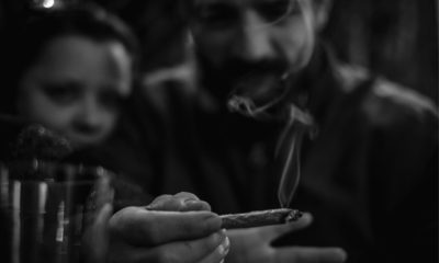 A black and white image of millenials smoking a joint even though they have been hired by the FBI to monitor internet crimes.