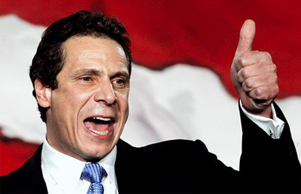 New York Gov. Andrew Cuomo stands in front of an American Flag holds his thumb up because he hasindicated today that a deal has been reached for the state to move forward with a limited medical marijuana program.