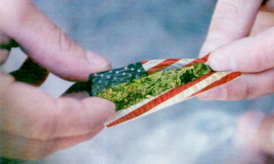Someone rolls up a joint in American flag papers for the 4th of July.