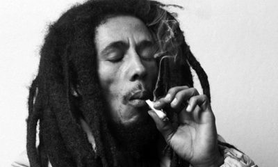 A black and white image of Bob Marley smoking a joint of Marley Naturalz brand marijuana.