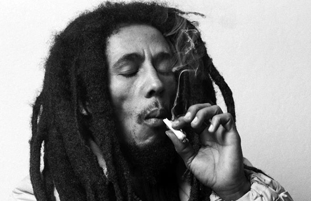 A black and white image of Bob Marley smoking a joint of Marley Naturalz brand marijuana.