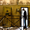 The shillouhette of a man stands in an abandoned prison, which he was just released from.