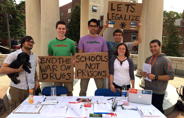 Members of the Students for Sensible Drug Policy (SSPD) hold signs saying "end the war on drugs" and "schools not prisons."