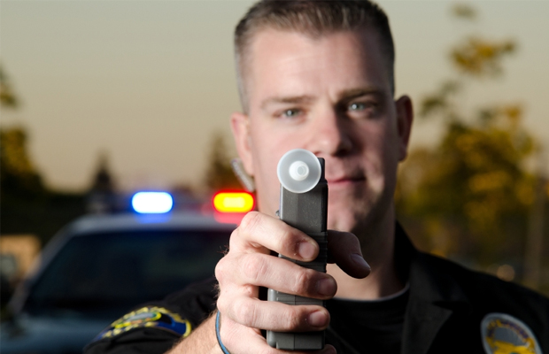A police officer holds out a breatalizer that can measure THC levels.