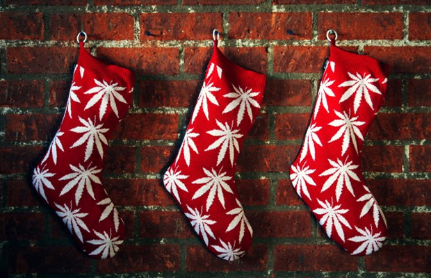 Three red stockings with white pot leaves patterned on them hold the perfect gifts for your stoner friends.