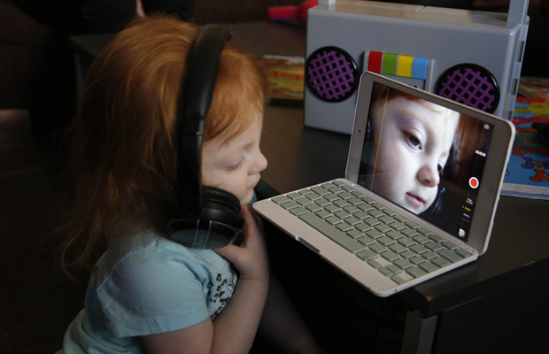 3-year-old Autumn Bay sits on a computer while she waits for her state, Missouri, to legalize CBD's so she can treat her siezures.