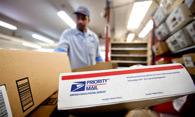 Flat Rate Box with MMJ Sits in Postal Cart to Be Organized by Postman