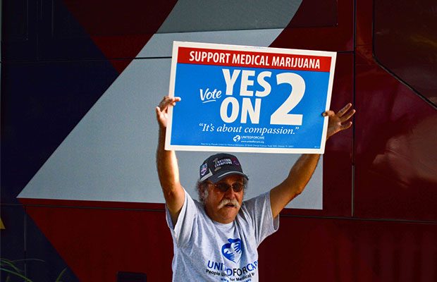Voter Holds Sign Saying "Vote Yes On 2" In Support of Legalization in Florida