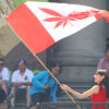 Woman Waves Canadian Flag with Red Pot Leaf in Middle