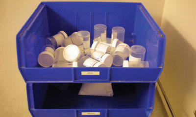 Urine Collection Bottles Sit Empty in a Blue Receptical