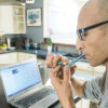 Man Smoking Marijuana While On Computer