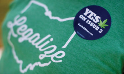 Green T-Shirt with a Message to Legalize Ohio and a Blue Pin with a Yes on Issue 3