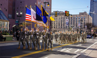 Veterans Parade Down a City Street with Flags