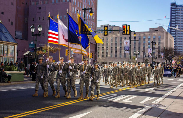 Veterans Parade Down a City Street with Flags
