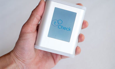 A hand holds the tCheck device which helps people dose their edibles correctly