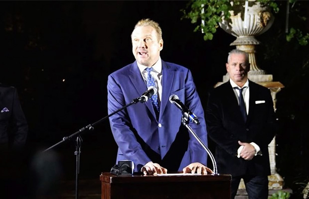 Big Mike's at a press conference wearing a blue suit while canceling his epic super bowl party at his marijuana mansion.