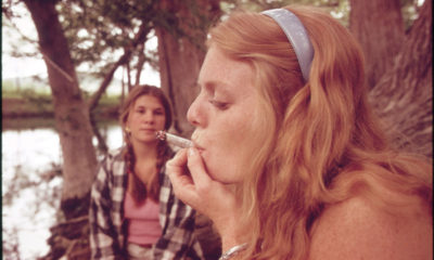 A 3x5 image of a woman in the 60s puffing on a joint while her friend watches on in conservative Texas.