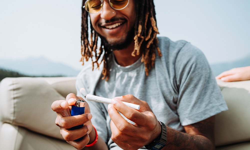 Man lighting joint using Hempire rolling papers