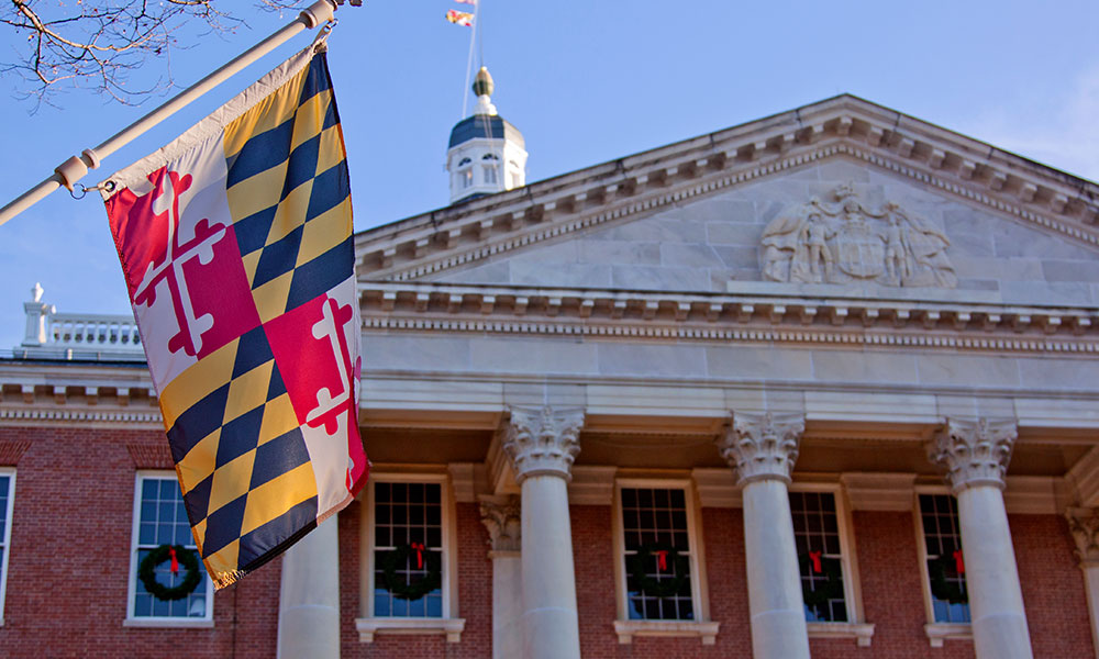 Maryland state flag in front of the capitol state house in Annapolis, MD
